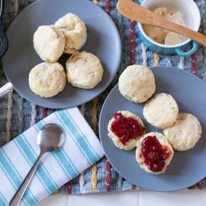 vegan buttery biscuits on a blue plate with jam on top